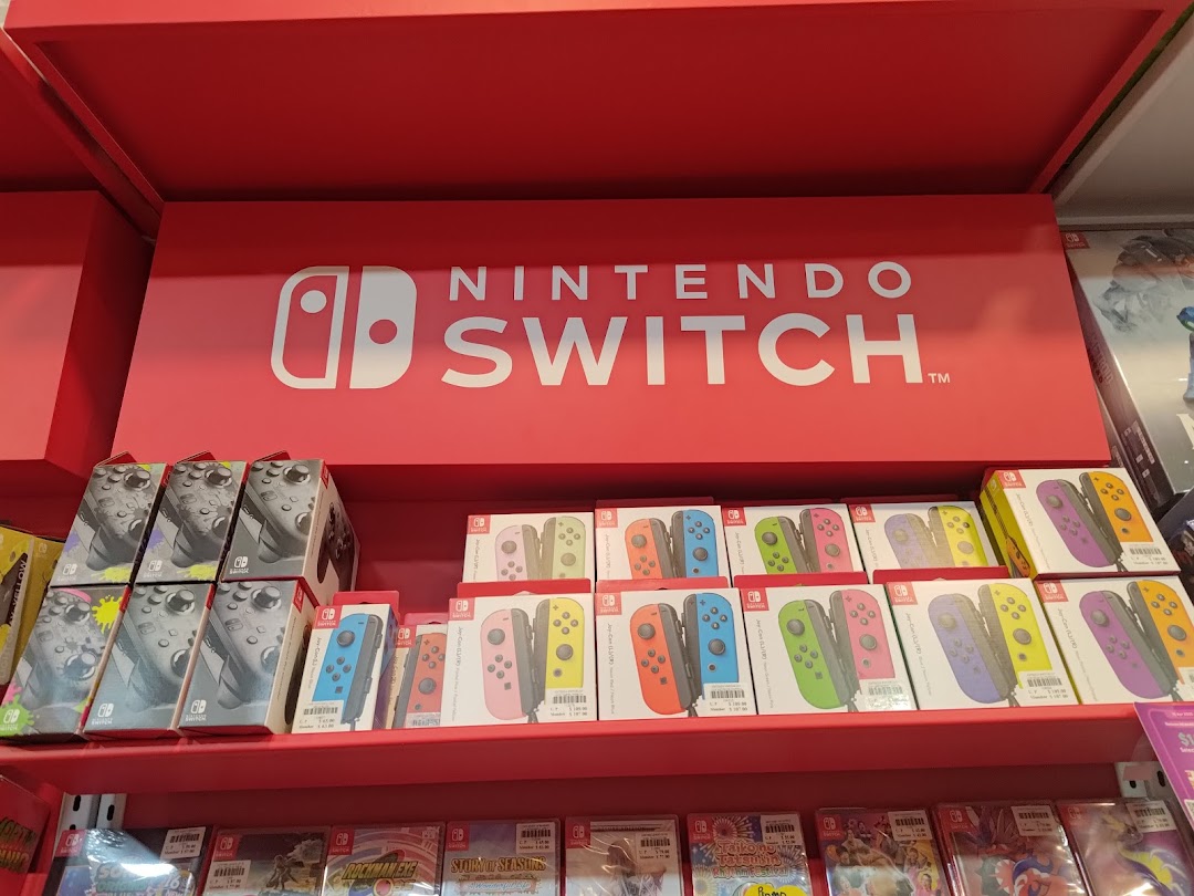 A vibrant display of Nintendo Switch consoles, Joy-Cons, and games on red shelves at Toy Or Game.