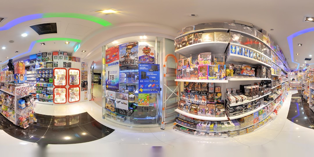 A wide-angle view of a vibrant retail store filled with video games, consoles, action figures, and various collectibles.