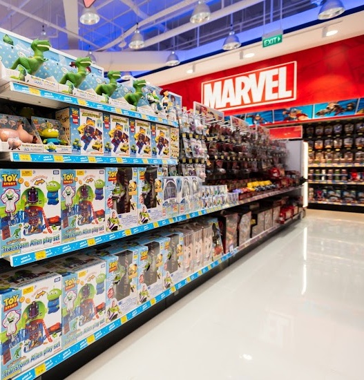 An interior view of ToysRUs, showcasing shelves filled with popular toys like Toy Story and Marvel merchandise.