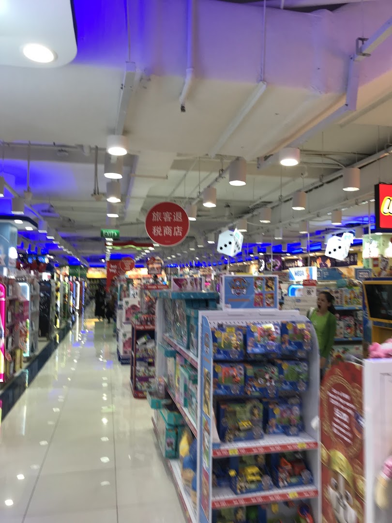 An aisle inside ToysRUs, showcasing shelves filled with various toys and a customer browsing.