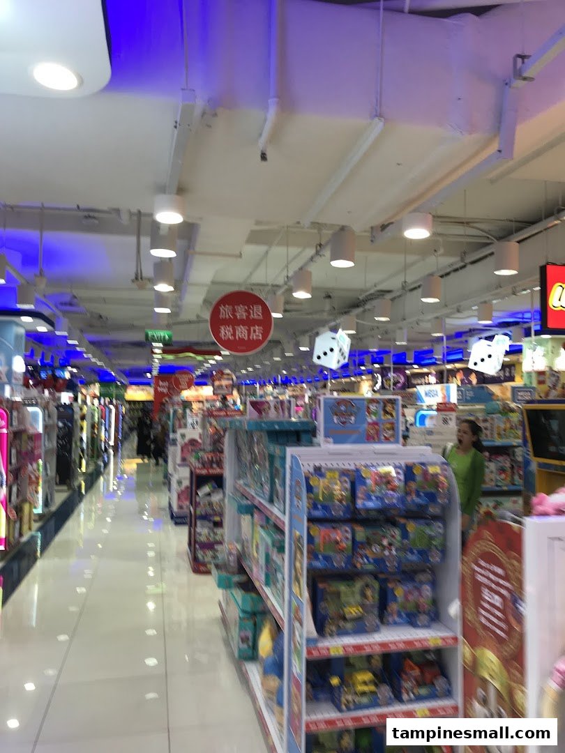 An aisle inside ToysRUs, showcasing shelves filled with various toys and a customer browsing.