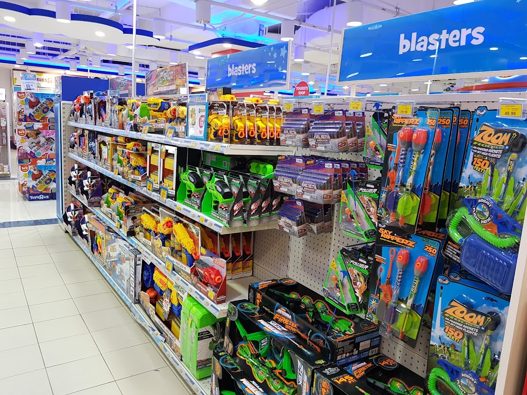 An aisle inside ToysRUs filled with various blasters, toy guns, and outdoor play items.
