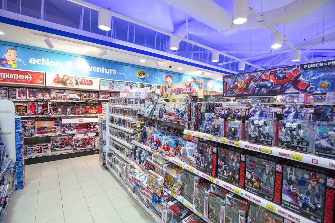 An interior shot of ToysRUs, featuring aisles stocked with action figures, Transformers, and Star Wars toys.