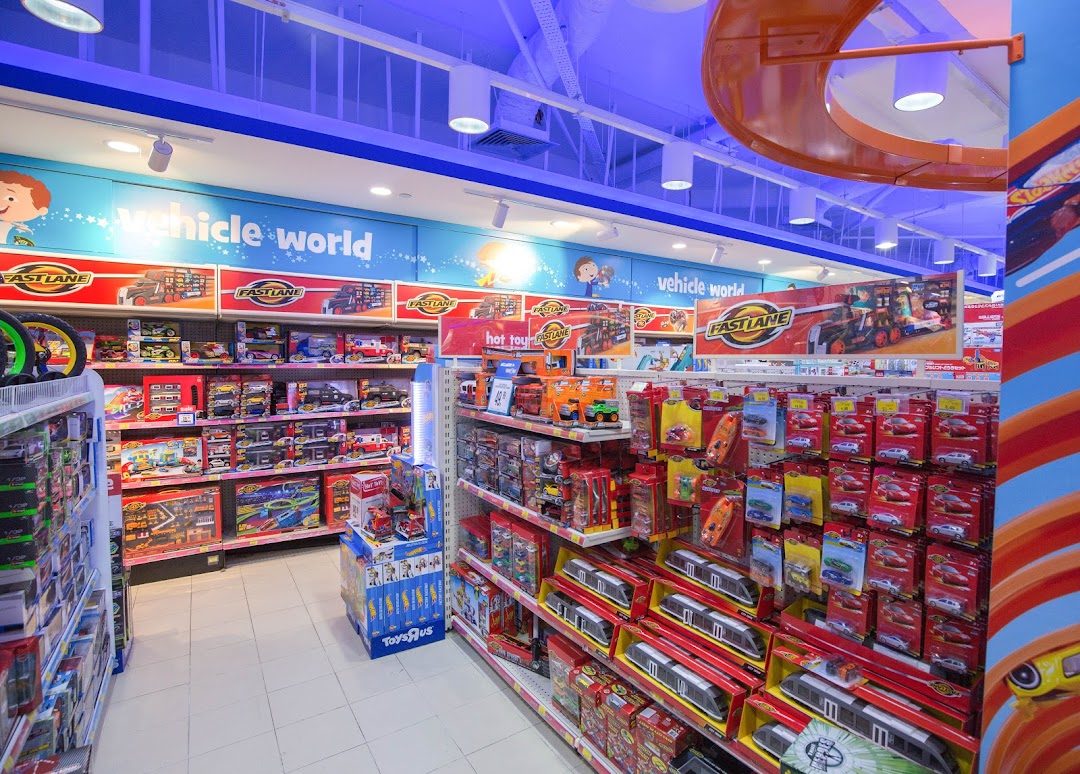 An aisle inside ToysRUs Tampines Mall, showcasing a wide selection of vehicle toys and playsets.