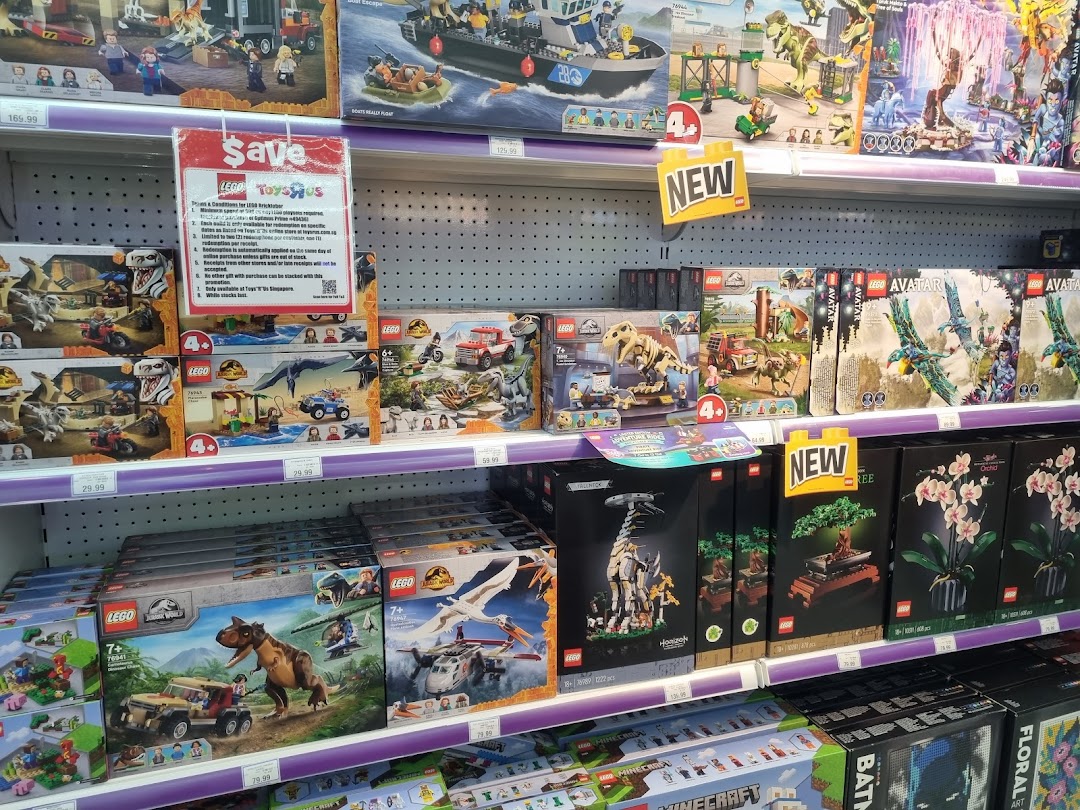 Shelves at ToysRUs filled with various LEGO sets, including Jurassic World, Avatar, and botanical collections.