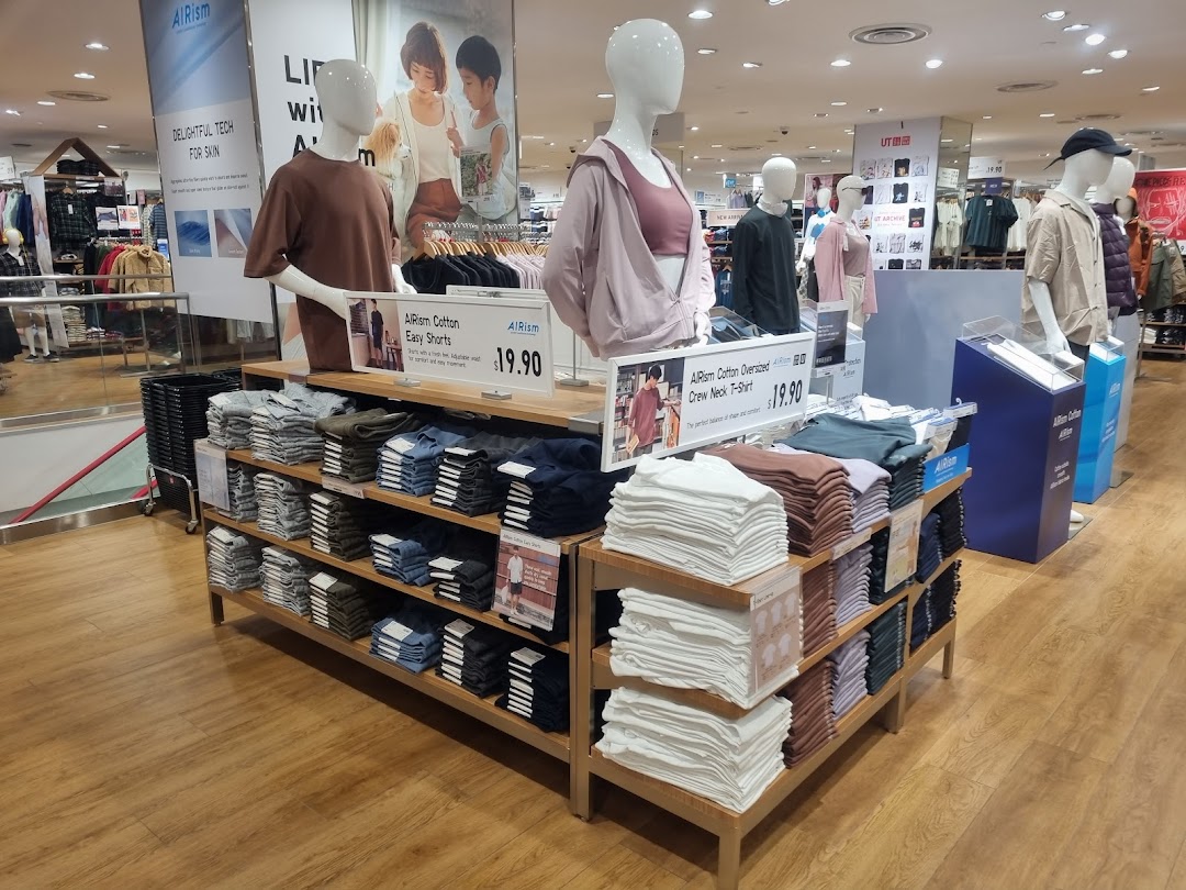 Mannequins display UNIQLO's AIRism collection with neatly folded apparel on wooden shelves.