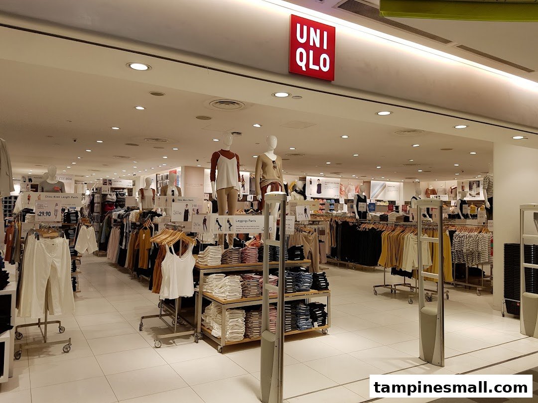 A brightly lit interior view of UNIQLO, showcasing various apparel on racks and mannequins.