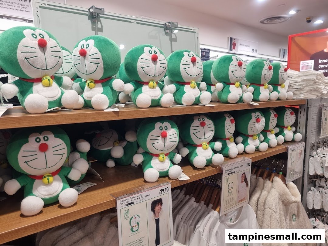 Shelves filled with green Doraemon plush toys and related apparel at UNIQLO.