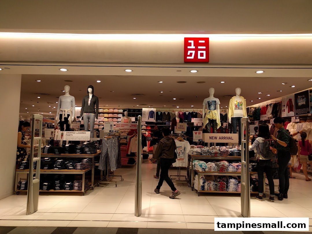 The brightly lit entrance of a UNIQLO store, showcasing mannequins and new apparel displays.