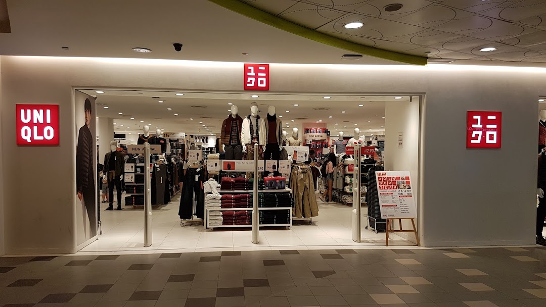 The brightly lit entrance of UNIQLO, showcasing mannequins and clothing displays inside.