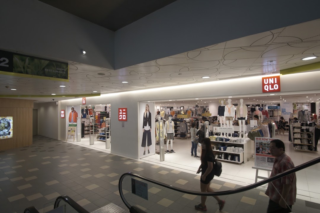 View of the UNIQLO store entrance from an escalator, showcasing mannequins and interior.