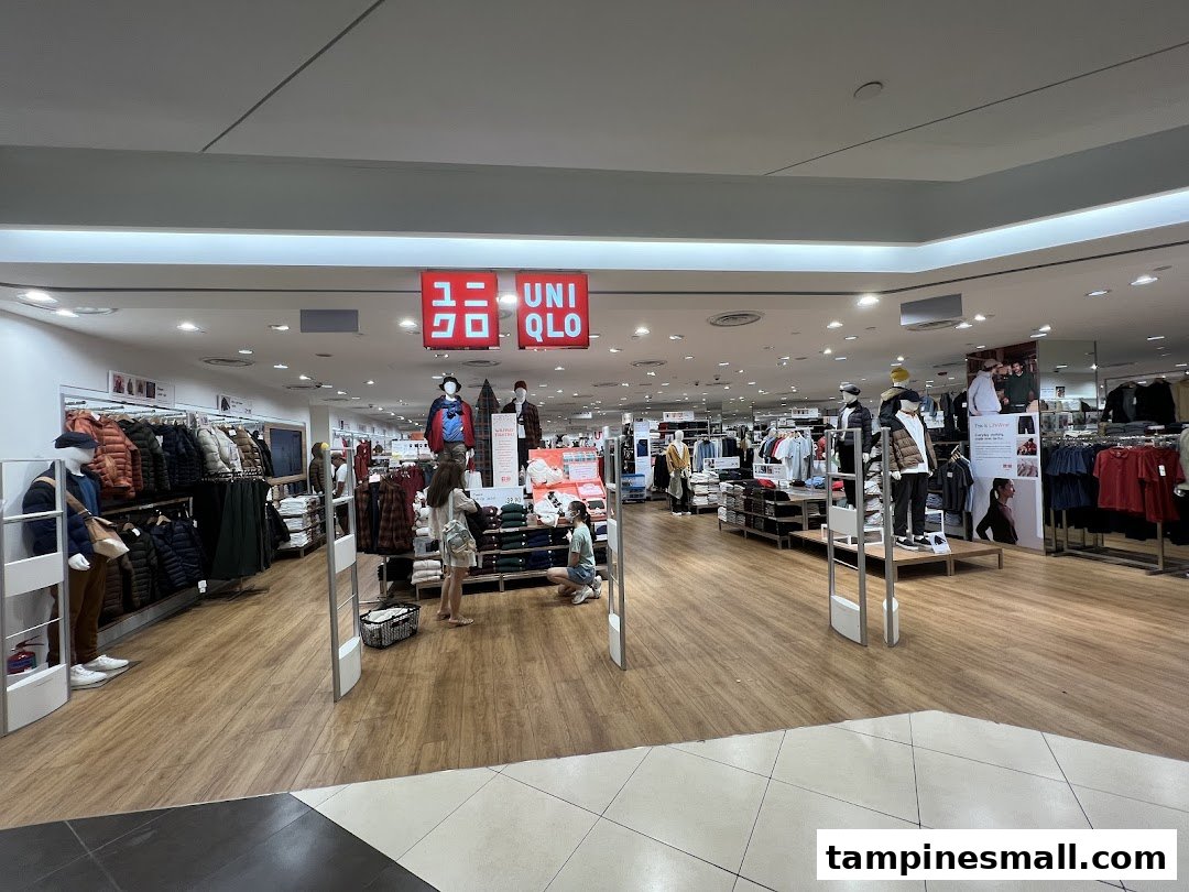 View of the UNIQLO store entrance with clothing displays and shoppers inside.