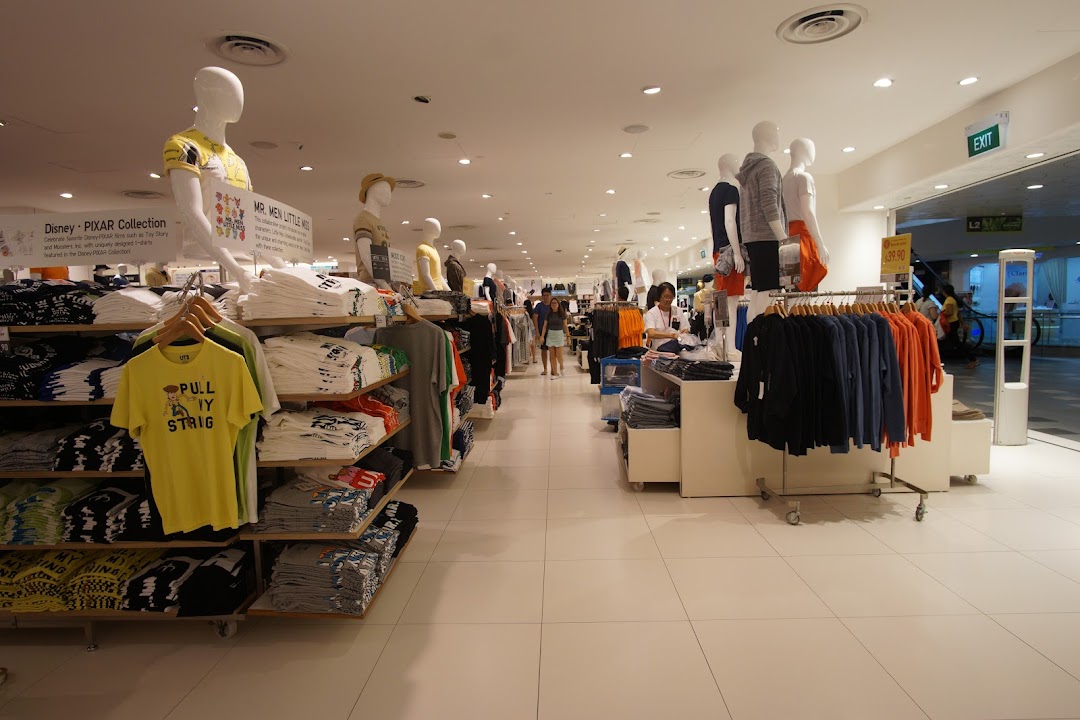 Interior view of UNIQLO showcasing diverse apparel collections, including Disney and Mr. Men Little Miss UT graphic tees.