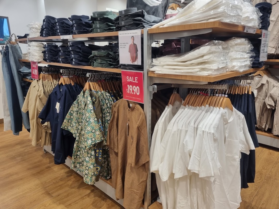 An interior view of UNIQLO showcasing racks of clothing, folded items on shelves, and a prominent sale sign.
