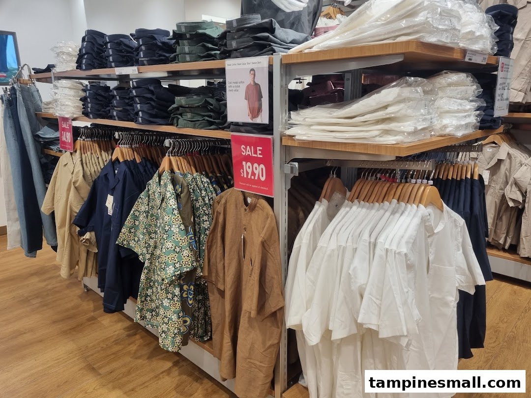 An interior view of UNIQLO showcasing racks of clothing, folded items on shelves, and a prominent sale sign.