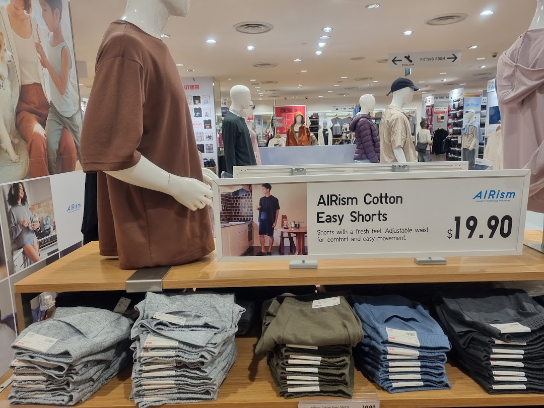 An in-store display at UNIQLO featuring AIRism Cotton Easy Shorts with mannequins and pricing.