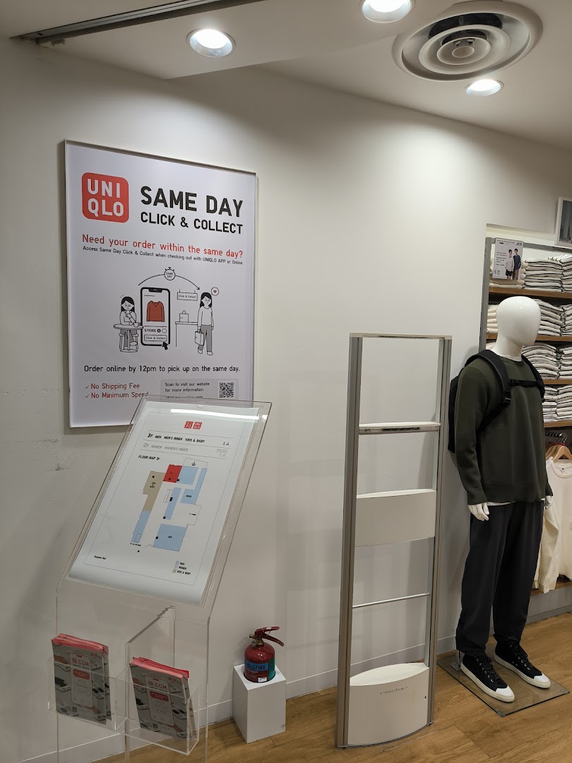 An in-store display at UNIQLO promoting their Same Day Click & Collect service, featuring a floor map and mannequin.