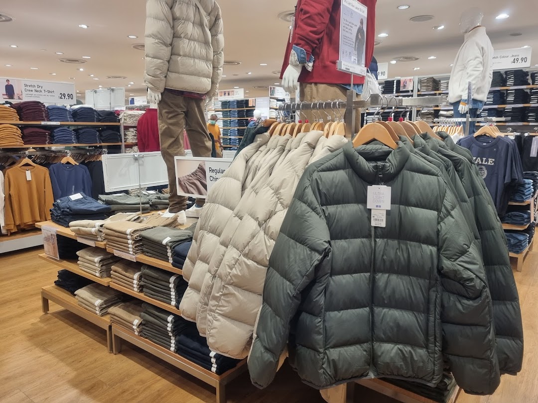 Interior view of UNIQLO featuring clothing displays, including Ultra Light Down jackets and folded apparel.