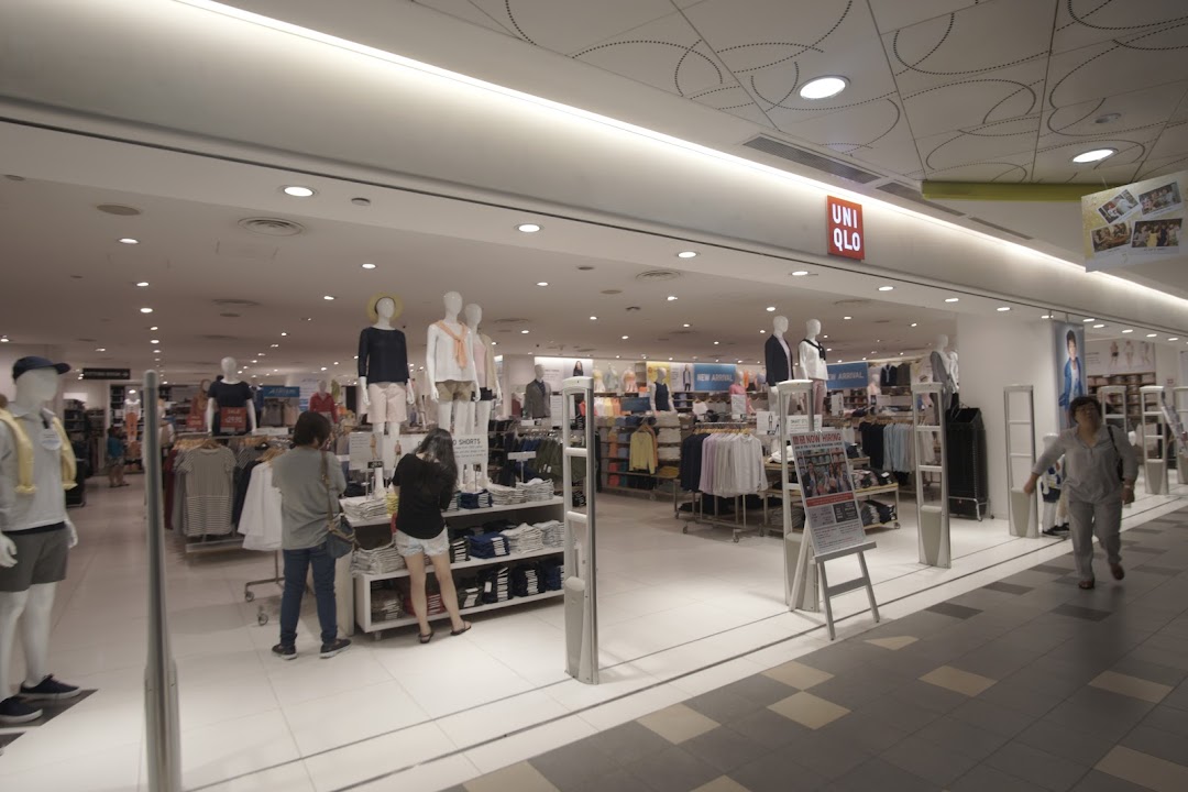 The UNIQLO store entrance at Tampines Mall, showcasing apparel on mannequins and customers browsing.