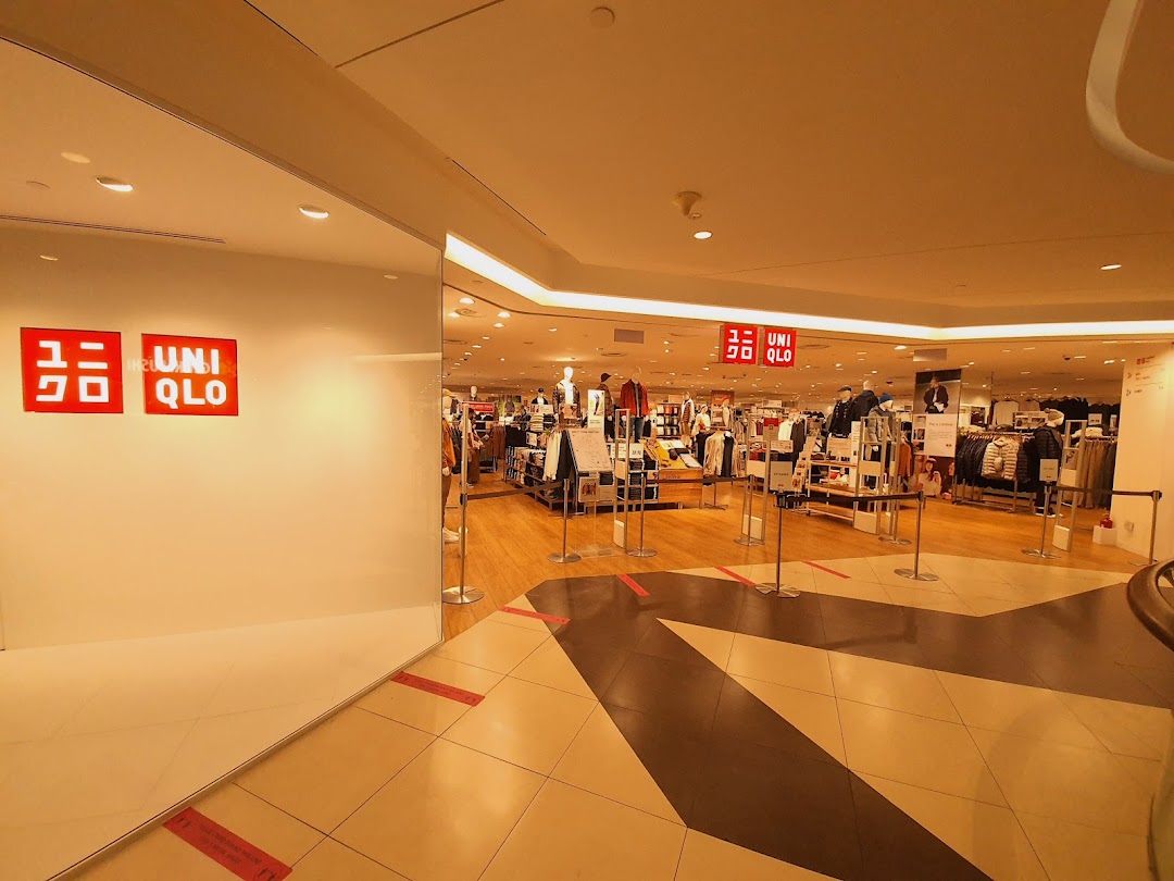 The inviting entrance of UNIQLO Tampines Mall, showcasing its spacious interior and diverse apparel.