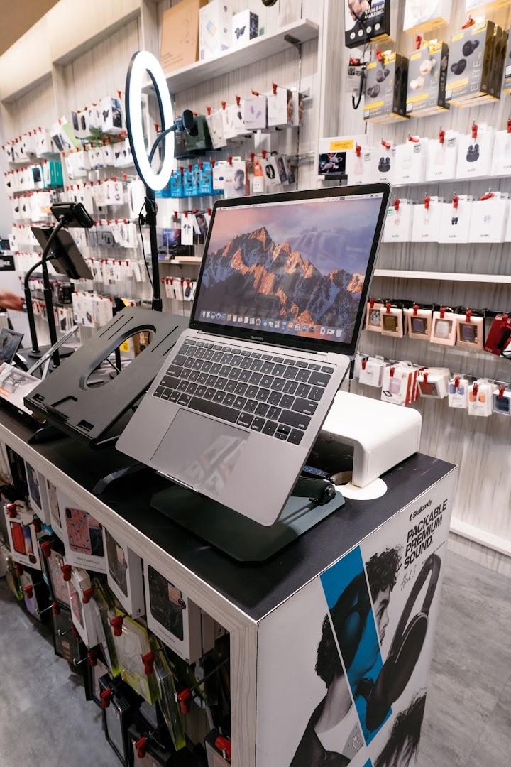 An interior shot of URBAN.M showcasing a display of electronics, accessories, and a laptop on a stand.