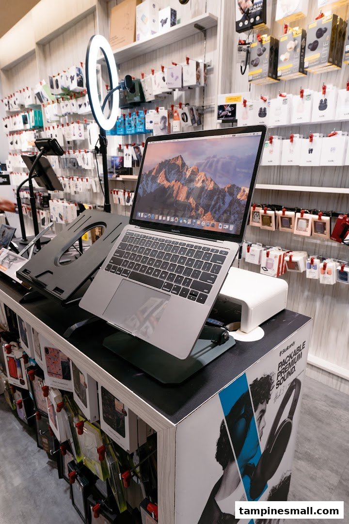 An interior shot of URBAN.M showcasing a display of electronics, accessories, and a laptop on a stand.
