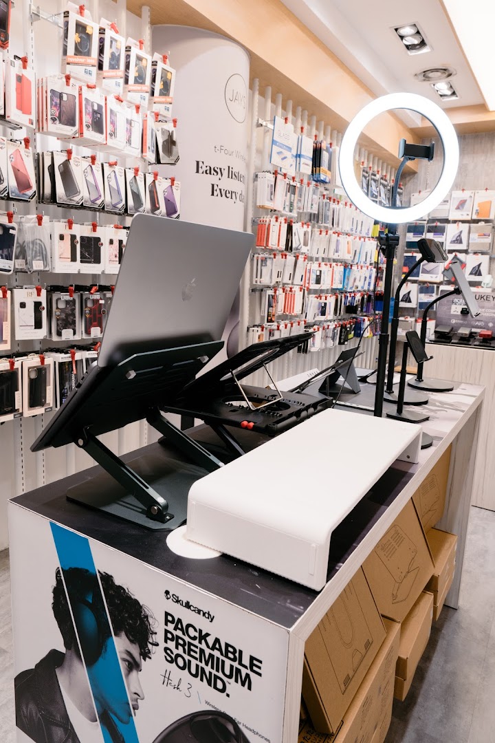 A retail display showcasing various tech accessories, including phone cases, laptop stands, and headphones.