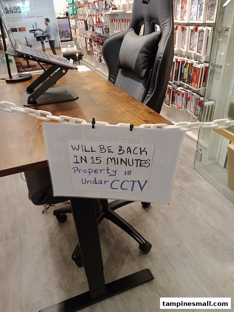 An interior view of URBAN.M, featuring tech accessories, a desk setup, and a temporary 'be back soon' sign.