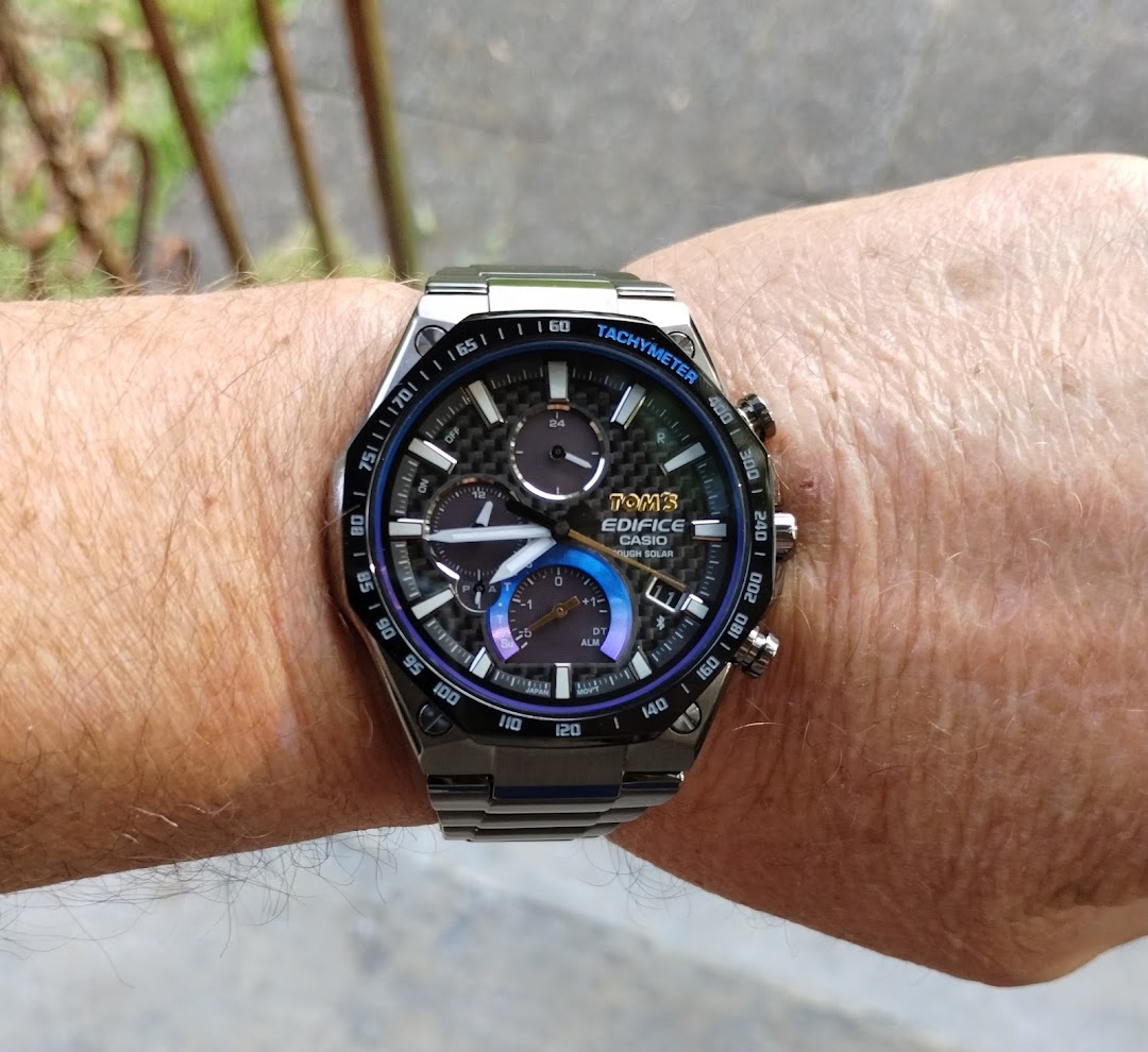 A close-up of a Casio Edifice watch with a carbon fiber dial on a person's wrist.