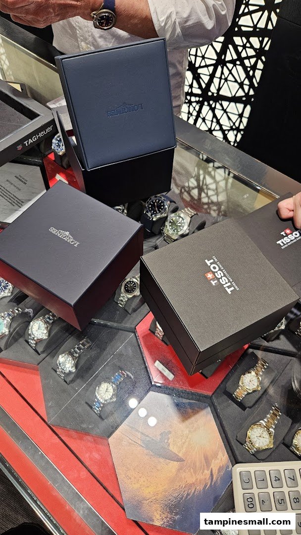 Luxury watch boxes from Longines and Tissot displayed on a counter with various watches.