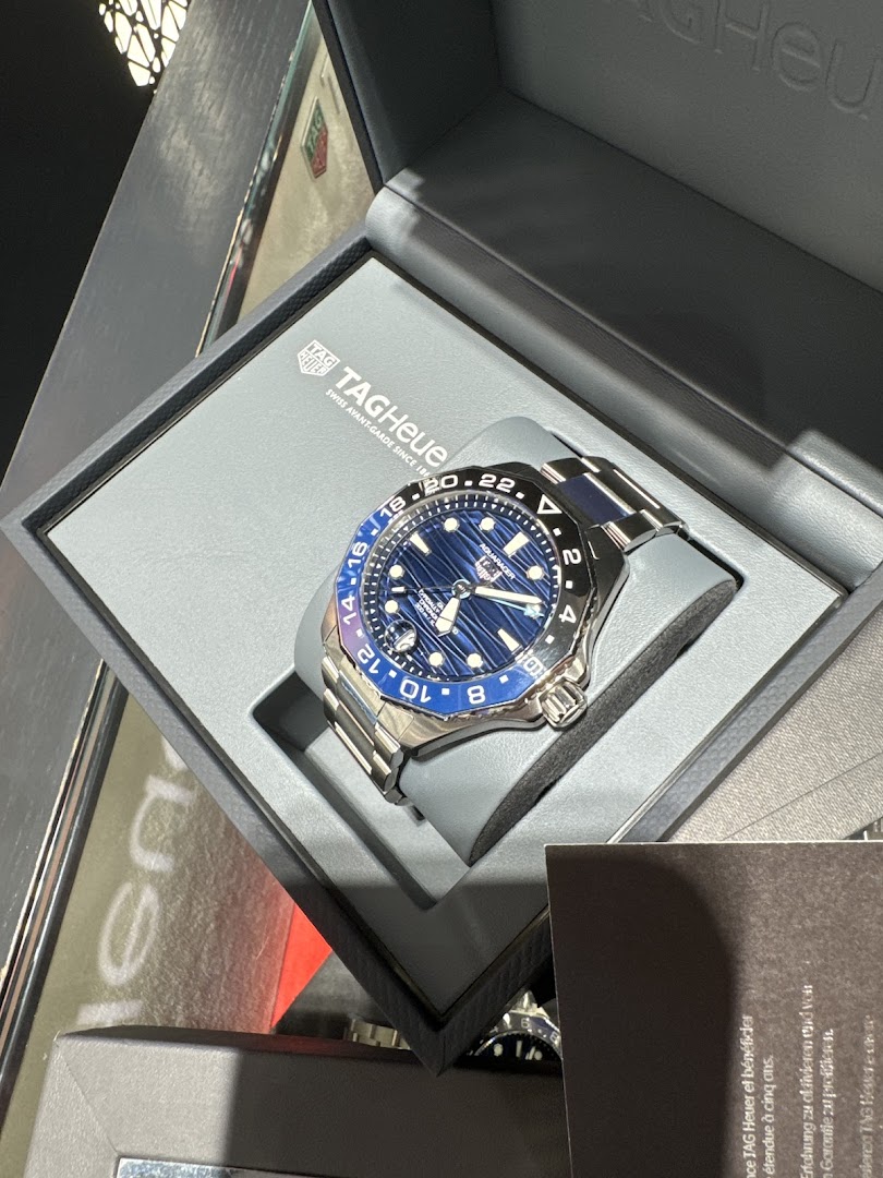 A close-up of a blue TAG Heuer Aquaracer GMT watch in its presentation box.