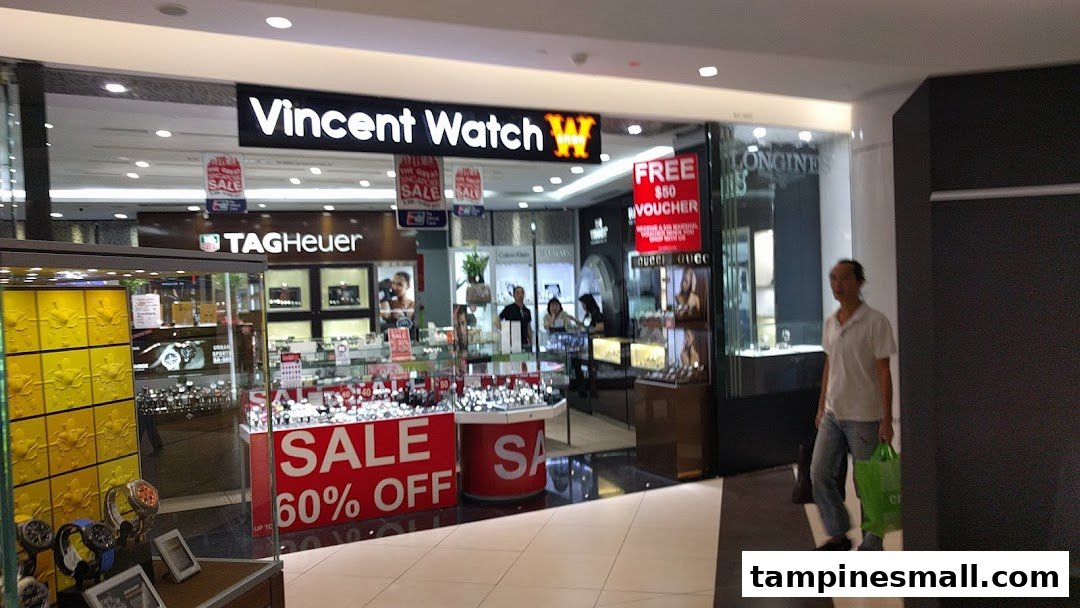 Exterior of Vincent Watch shop, displaying luxury timepieces, prominent sales, and brands like TAG Heuer and Longines.