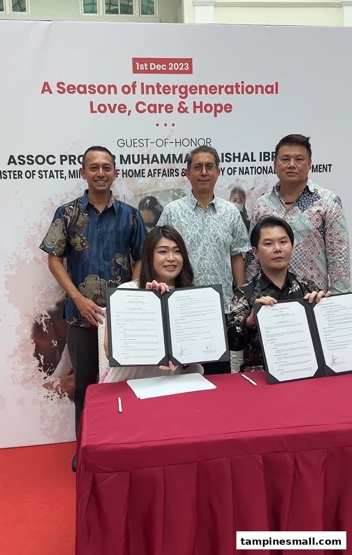Individuals, including a guest of honor, sign documents at an event themed 'A Season of Intergenerational Love, Care & Hope'.