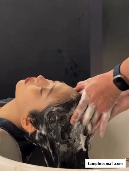 A customer receives a relaxing hair wash service at a salon.