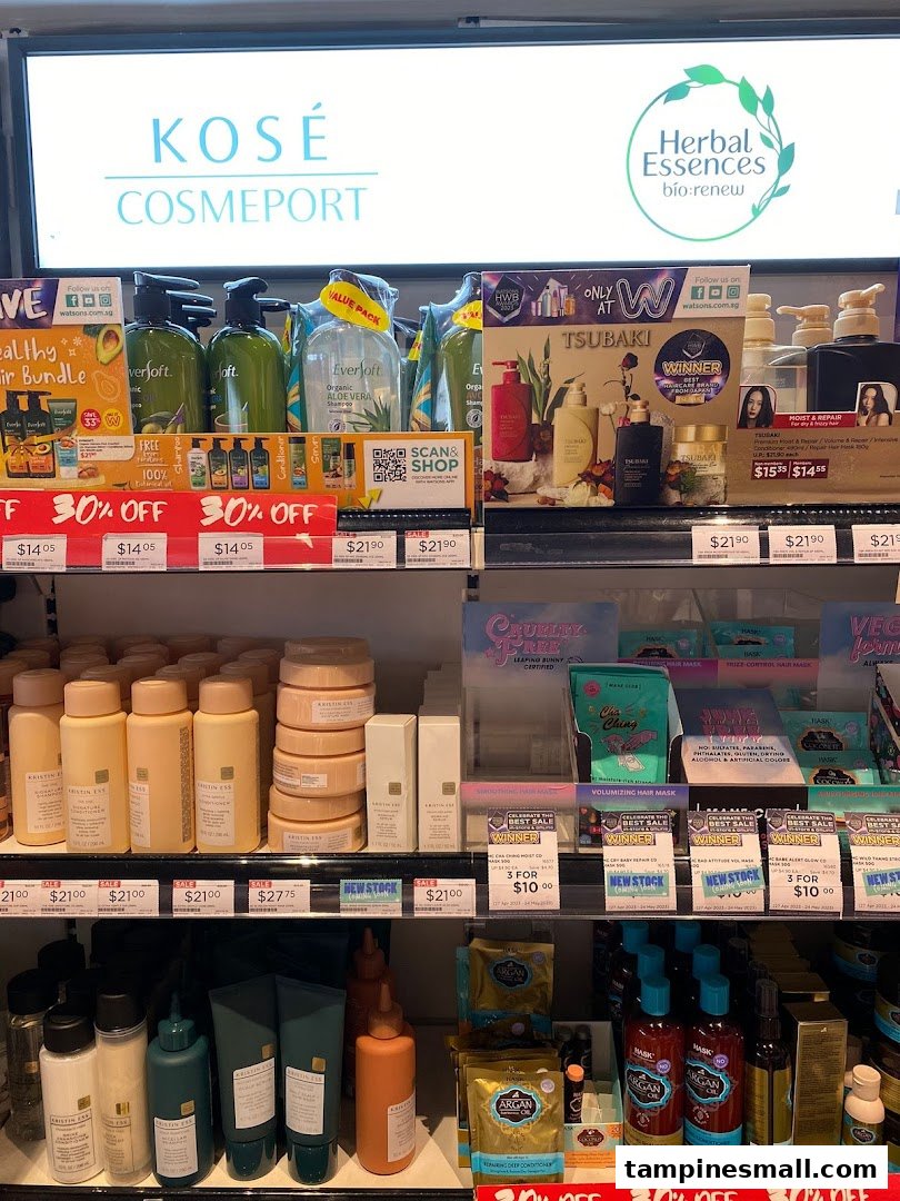 A display of various hair care products, including shampoos, conditioners, and treatments, from brands like Kose, Herbal Essences, Tsubaki, and Kristin Ess.