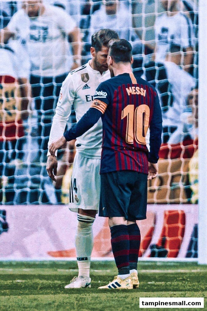 Two legendary football players, Lionel Messi and Sergio Ramos, face each other on a soccer field.