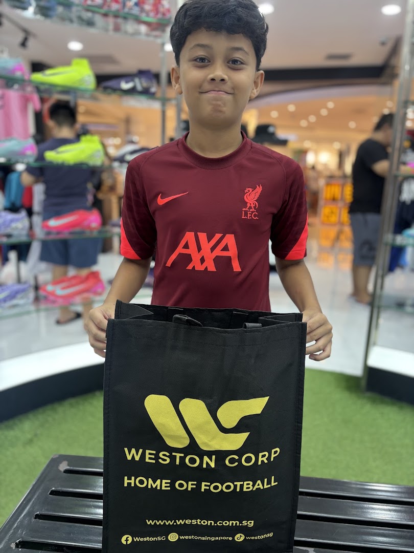 A young boy in a football jersey holds a Weston Corp shopping bag inside the vibrant sports store.