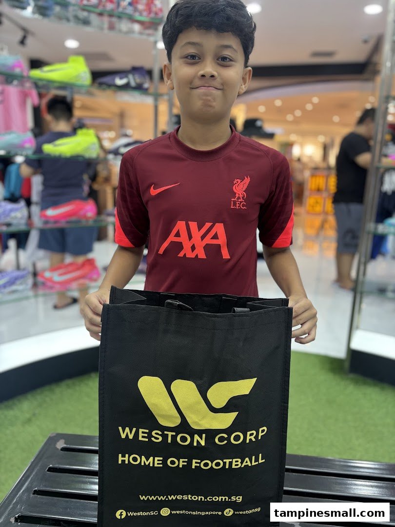A young boy in a football jersey holds a Weston Corp shopping bag inside the vibrant sports store.