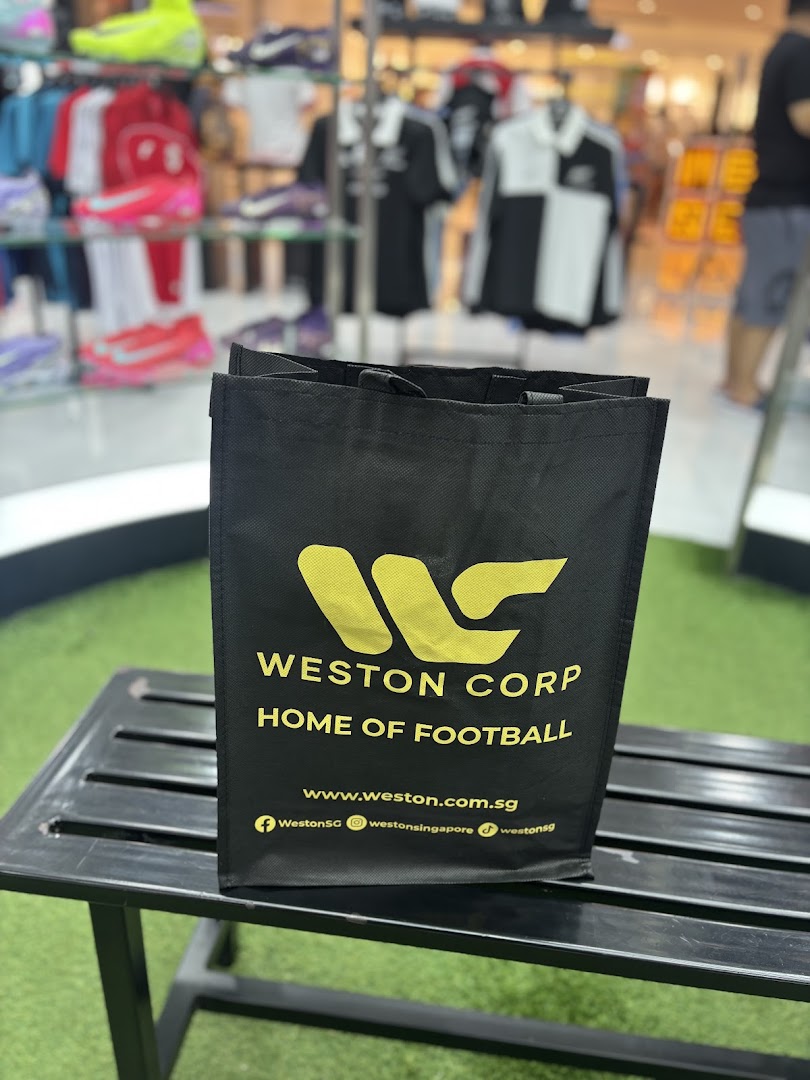 A black Weston Corp shopping bag with 'Home of Football' branding, in a sports retail store.