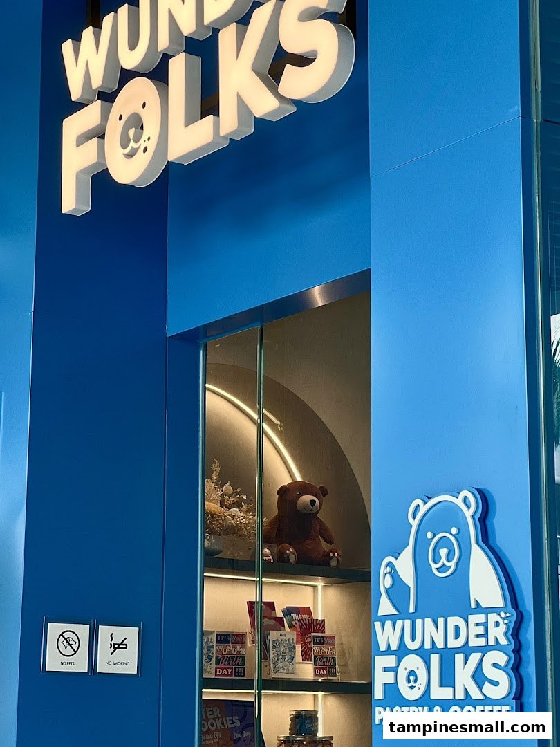 The vibrant blue exterior of Wunderfolks Pastry & Coffee, featuring its distinctive bear logo and display window.