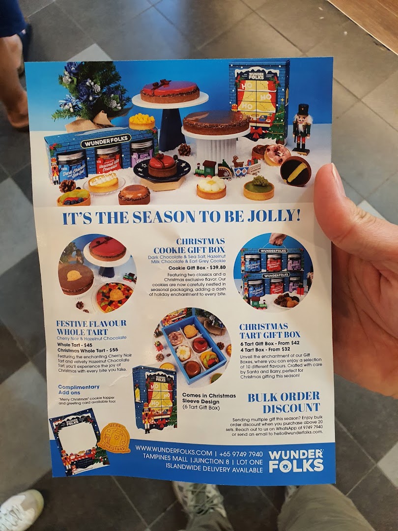 A festive Christmas menu flyer from Wunderfolks, showcasing holiday-themed tarts, cookies, and gift boxes.