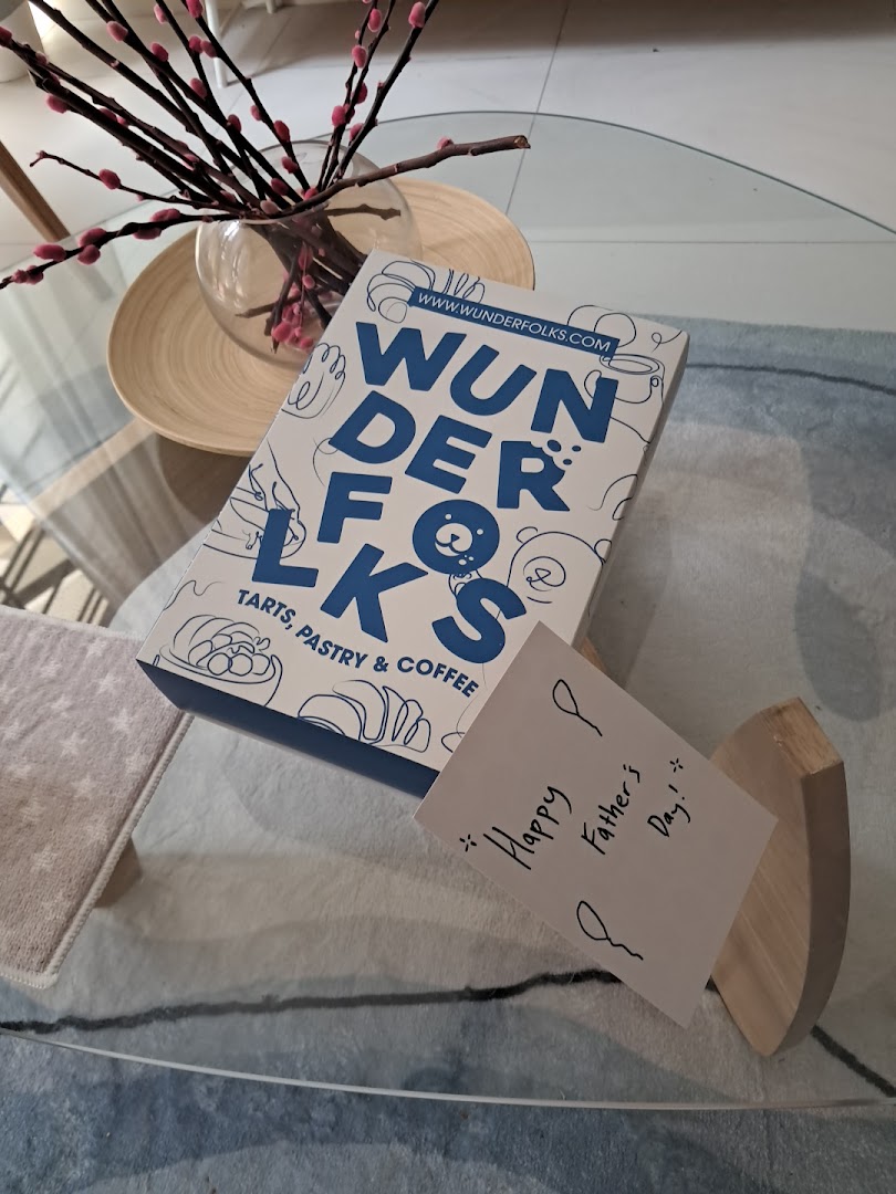 A Wunderfolks Pastry & Coffee box and a 'Happy Father's Day!' note on a glass table.