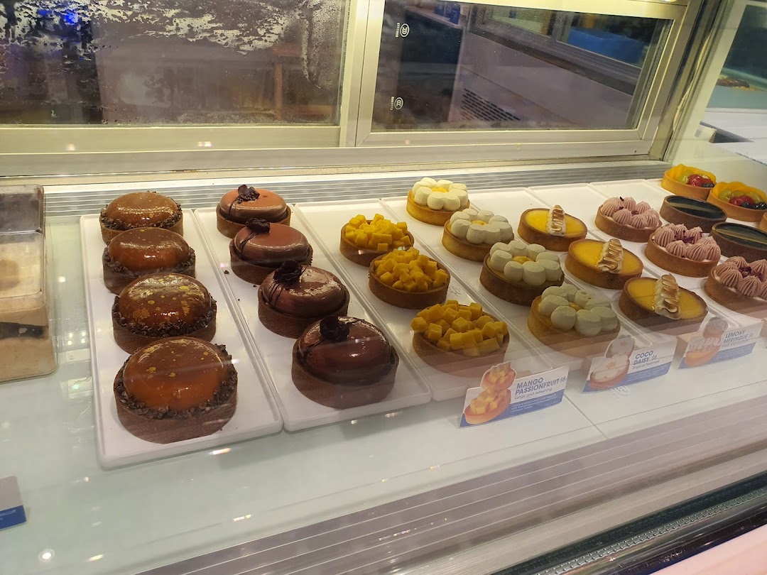 A vibrant display of assorted tarts and pastries in a chilled showcase at Wunderfolks.