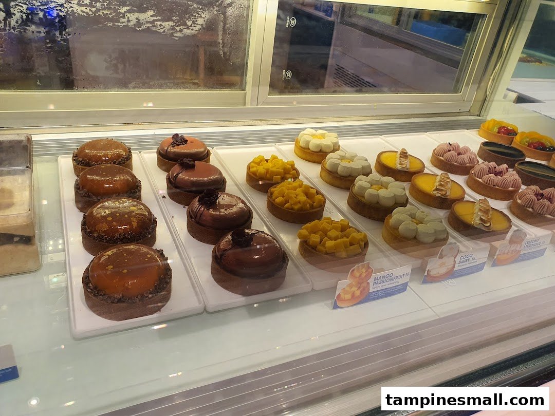 A vibrant display of assorted tarts and pastries in a chilled showcase at Wunderfolks.