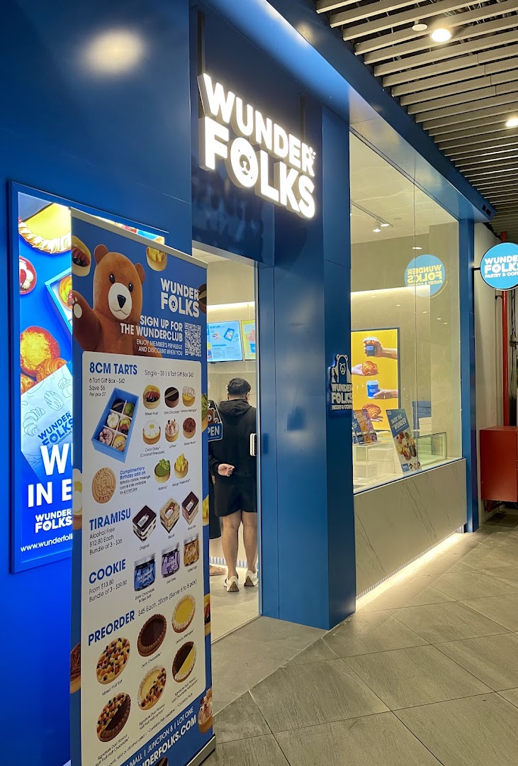 The vibrant blue shopfront of Wunderfolks Pastry and Coffee, featuring a promotional banner with tarts and pastries.