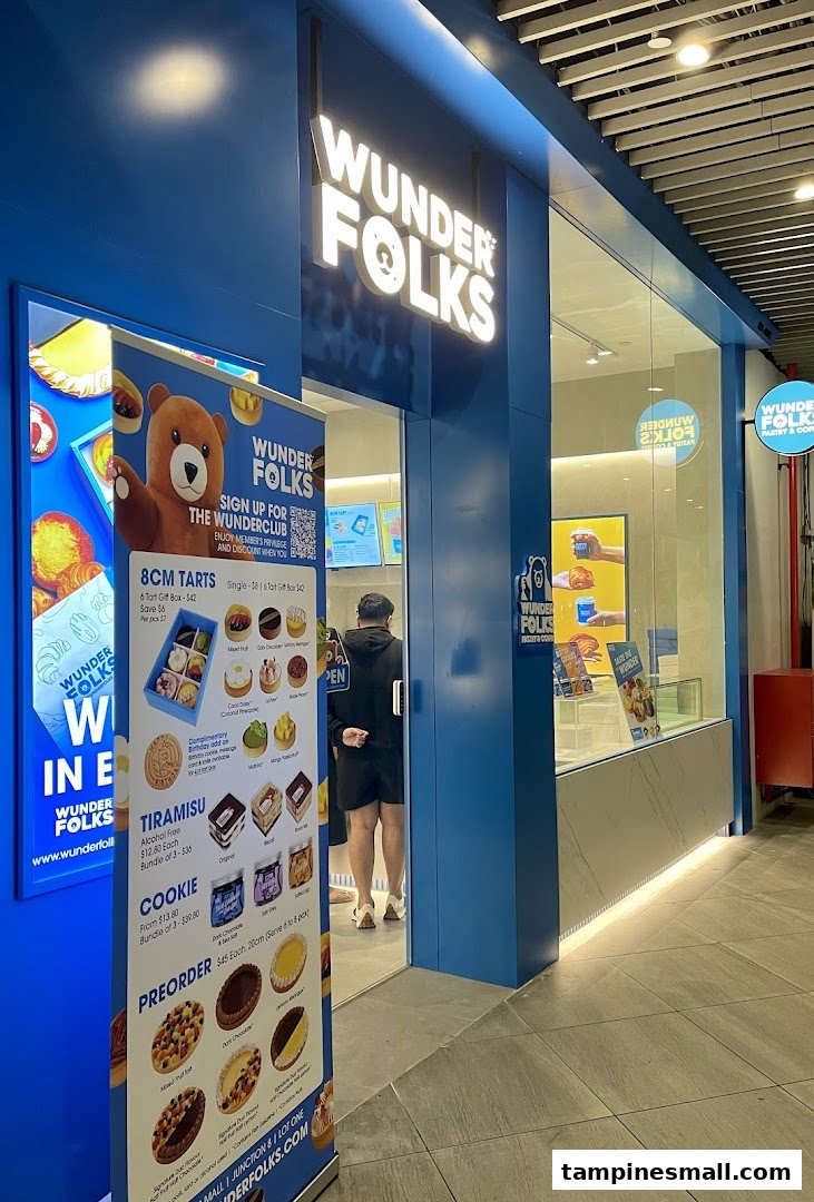 The vibrant blue shopfront of Wunderfolks Pastry and Coffee, featuring a promotional banner with tarts and pastries.