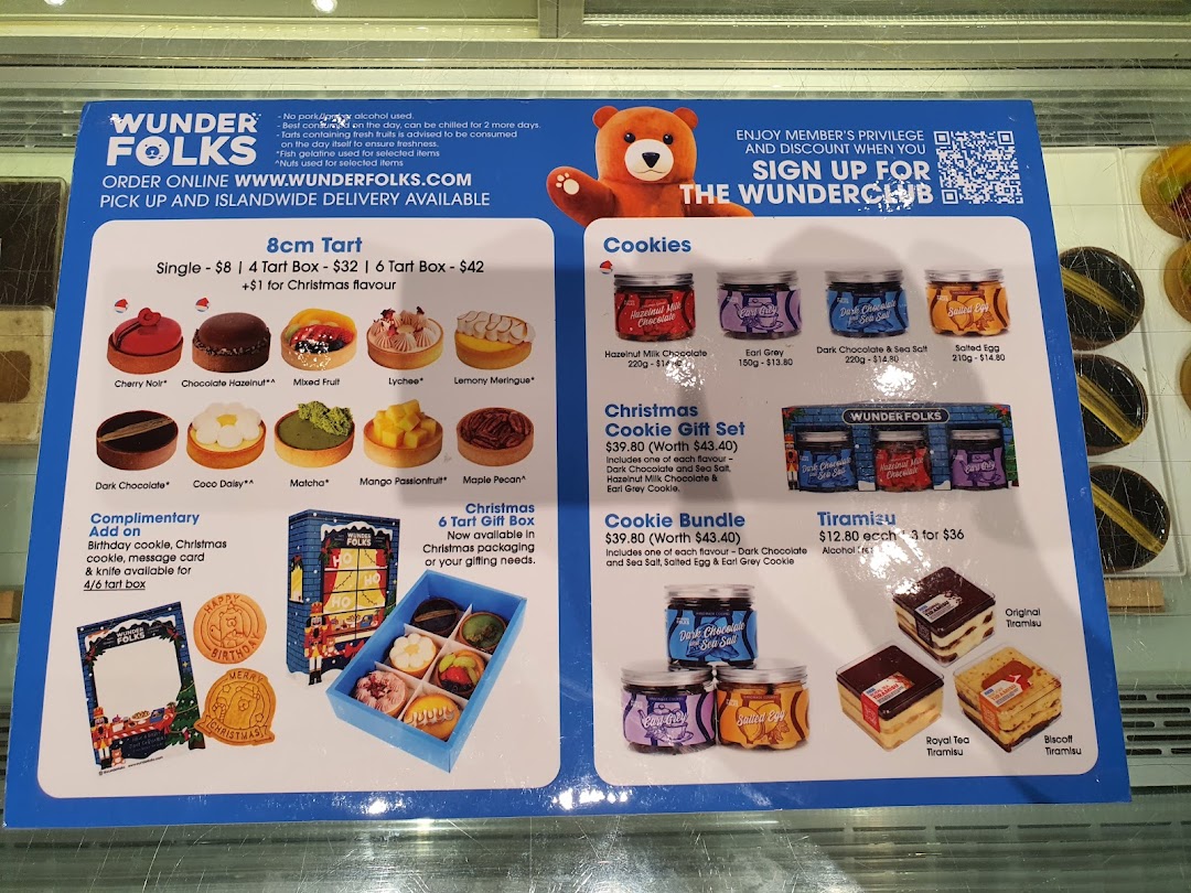 A detailed menu board showcasing tarts, cookies, and tiramisu from Wunderfolks Pastry and Coffee.