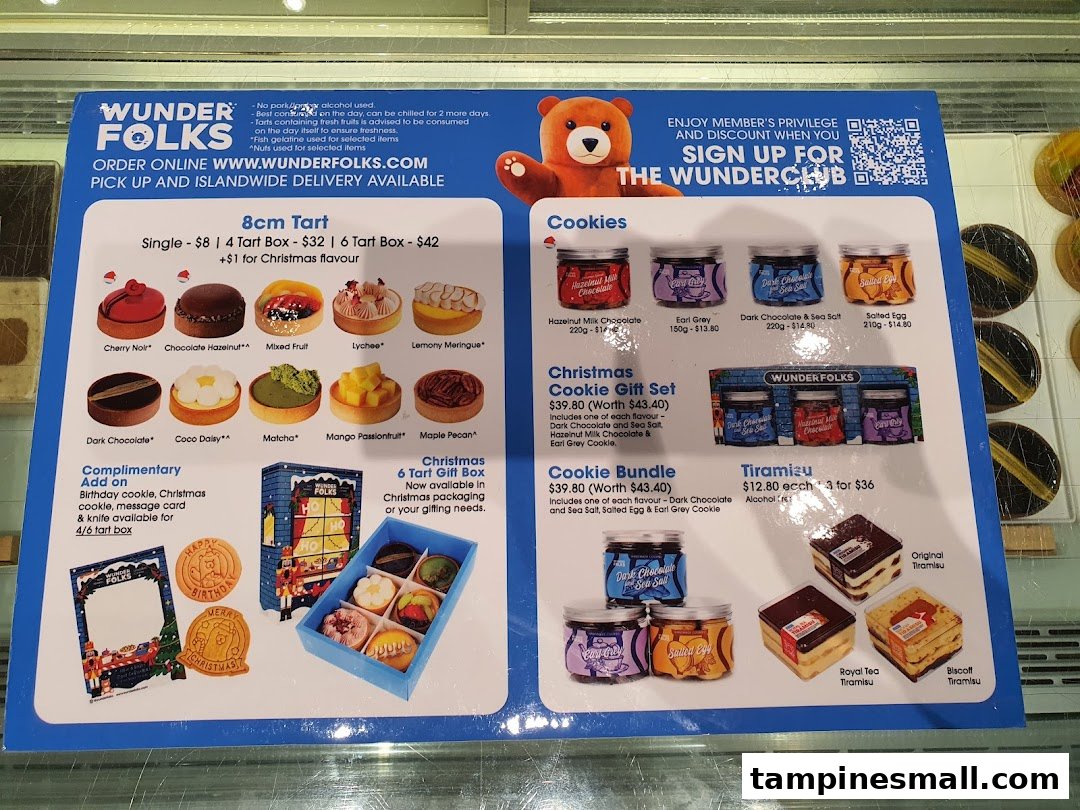 A detailed menu board showcasing tarts, cookies, and tiramisu from Wunderfolks Pastry and Coffee.