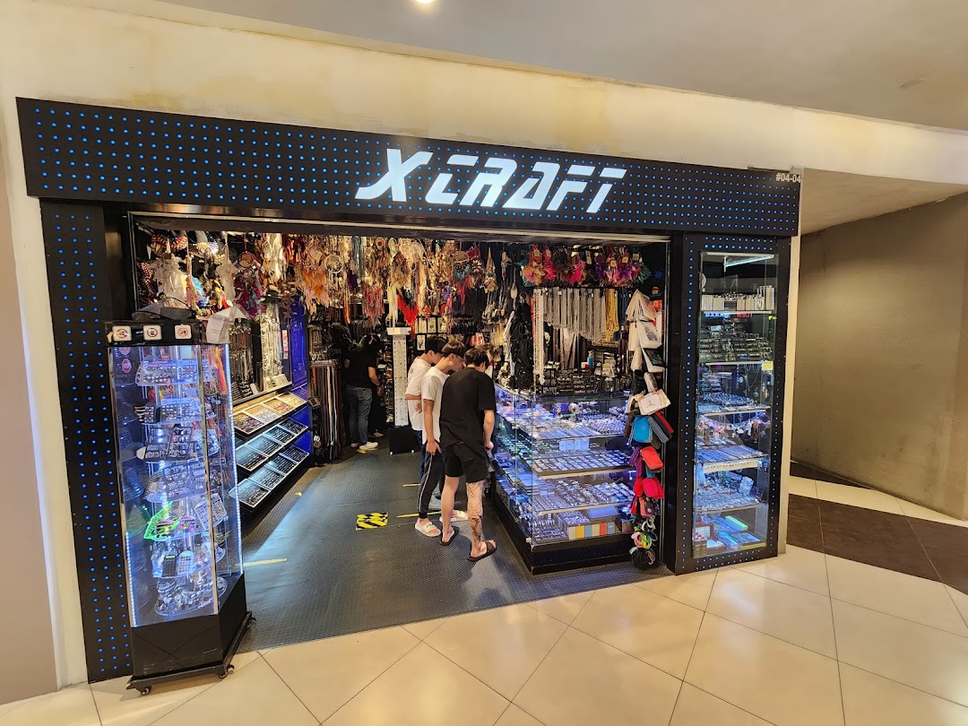 The storefront of X-Craft, an accessories and novelty shop, with customers browsing inside.