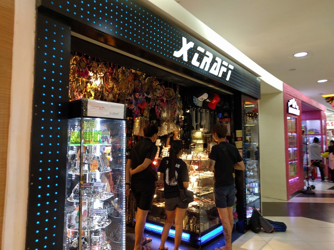 Customers browse unique accessories and gifts at the X-Craft shop entrance in a mall.